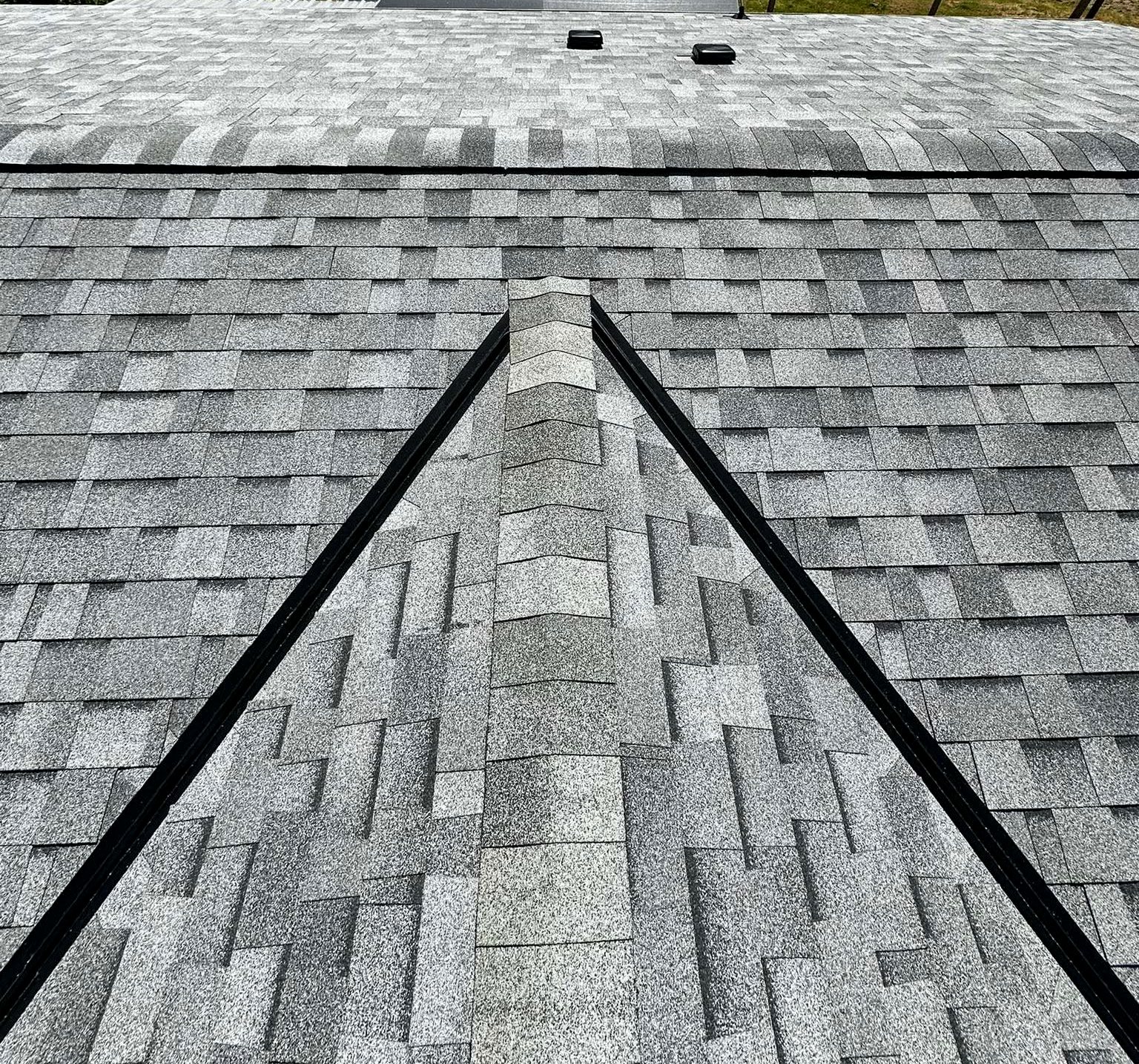 A Pacific Peaks Roofing shingle roof with the company's signature metal valley detail running down the center